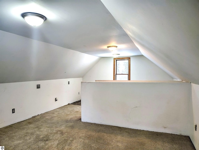 bonus room with lofted ceiling and carpet flooring