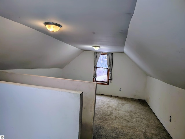 bonus room with vaulted ceiling and carpet floors