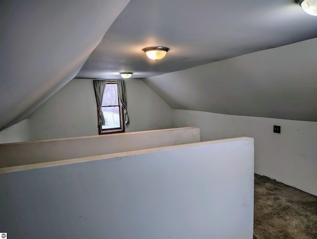 additional living space with dark carpet and vaulted ceiling