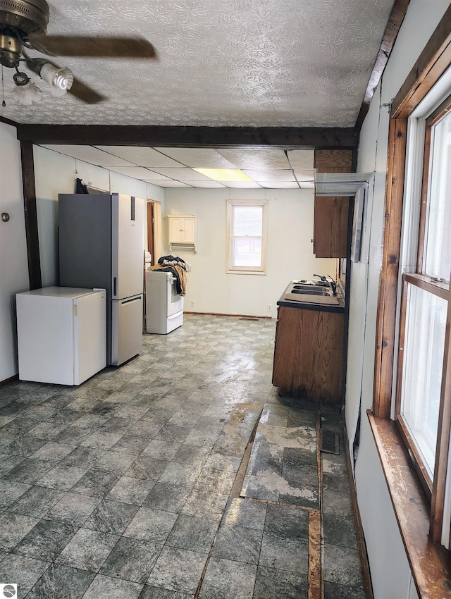 kitchen with washer / clothes dryer, a textured ceiling, fridge, and ceiling fan