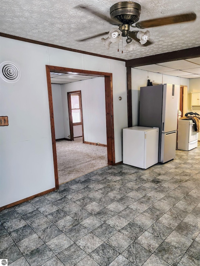 unfurnished living room with washer / clothes dryer, ornamental molding, ceiling fan, and a textured ceiling