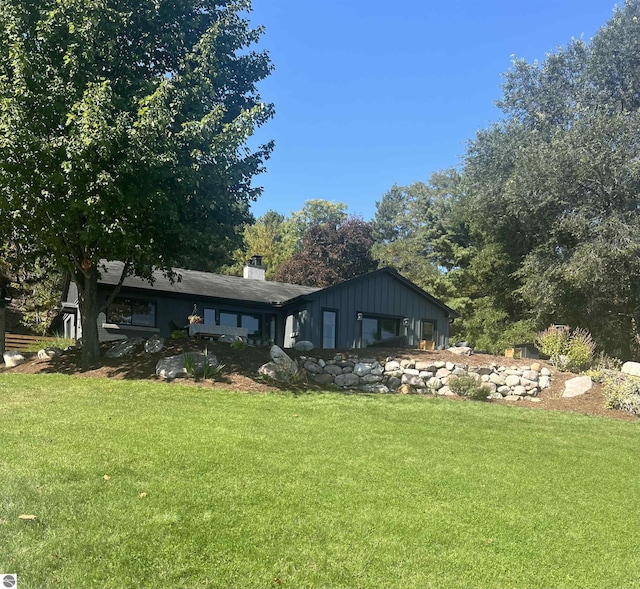 rear view of property with a lawn