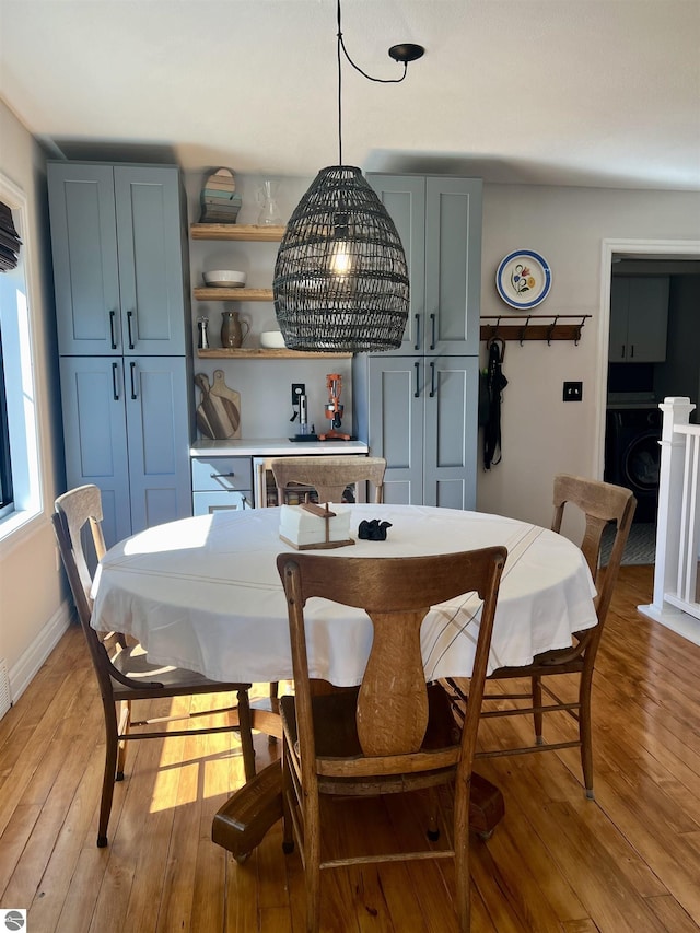 dining space featuring washer / dryer and light hardwood / wood-style flooring