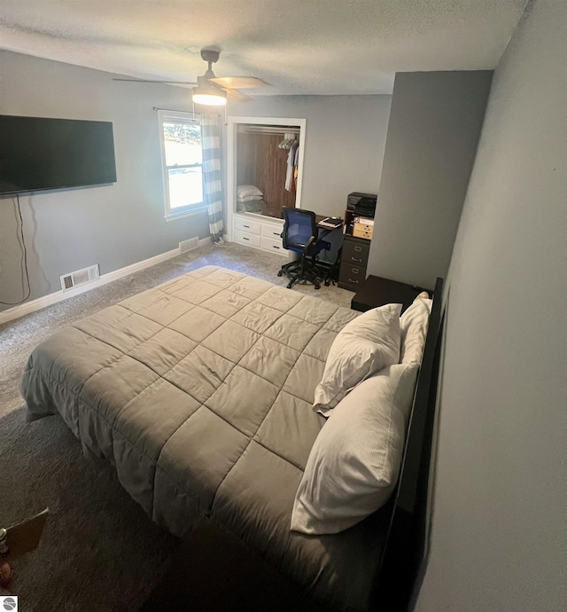 bedroom featuring ceiling fan, light colored carpet, a closet, and a textured ceiling