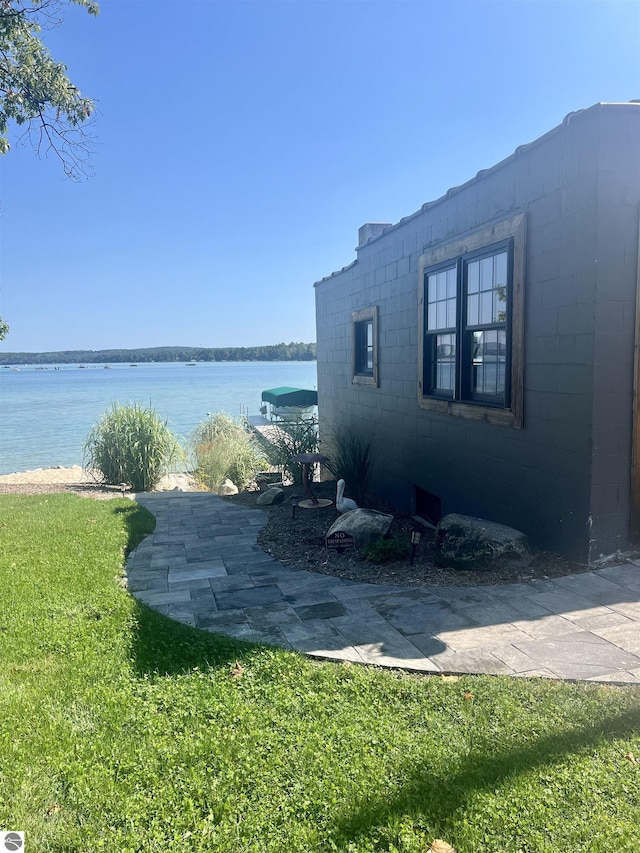 exterior space with a water view and a lawn