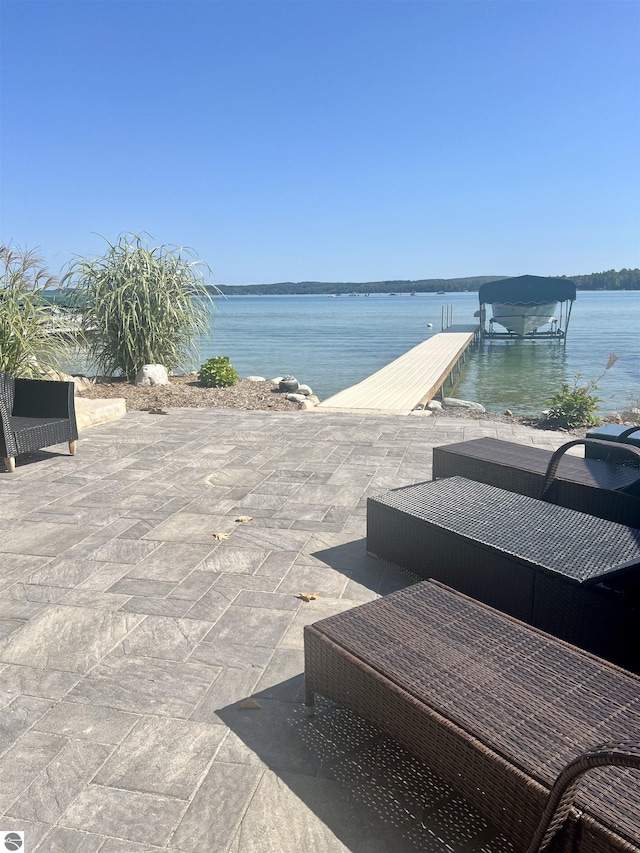 view of patio / terrace featuring a water view and a dock