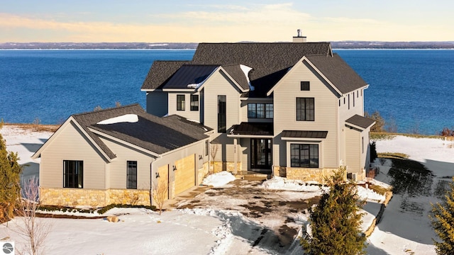 view of front of home featuring a water view, a garage, and a beach view