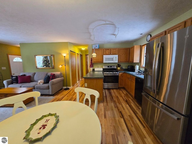 kitchen with pendant lighting, appliances with stainless steel finishes, hardwood / wood-style floors, and plenty of natural light