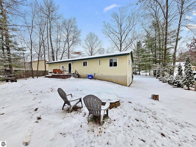 snow covered rear of property featuring a deck