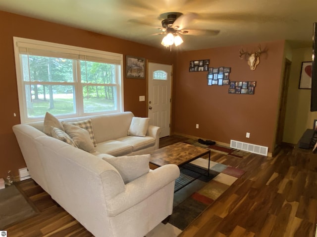 living room featuring dark wood-type flooring and ceiling fan