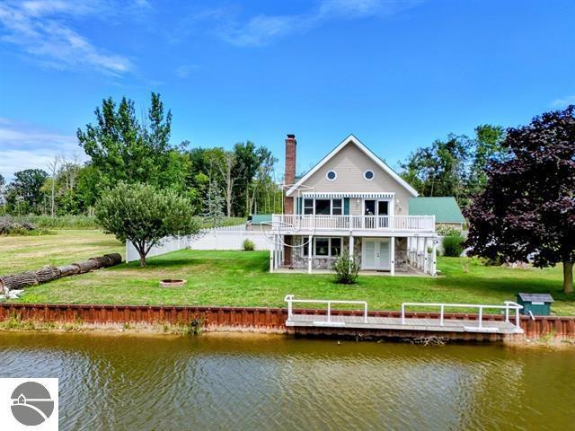 back of house with a water view and a yard