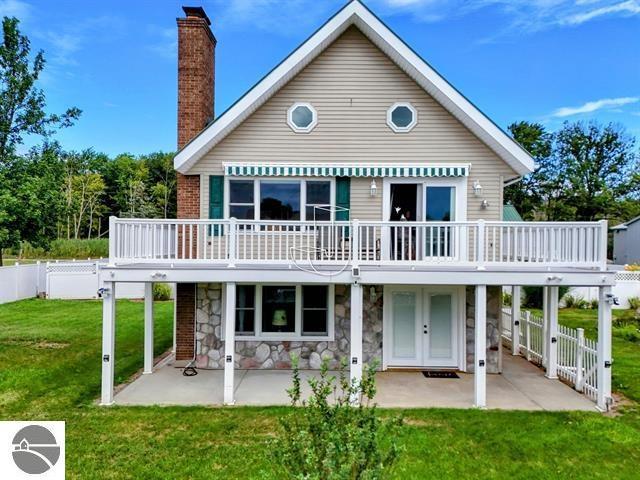 back of house featuring a yard, a deck, and a patio