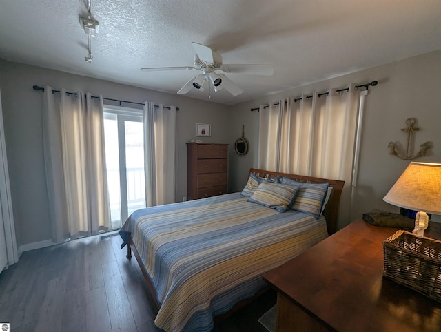 bedroom with ceiling fan, dark hardwood / wood-style flooring, and a textured ceiling