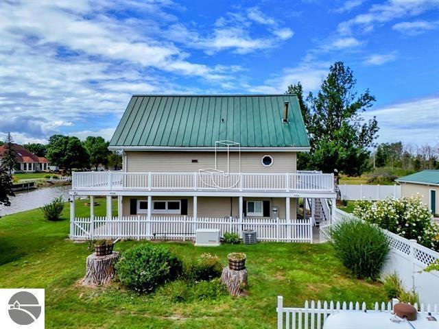 back of property with a yard, central AC, and a deck