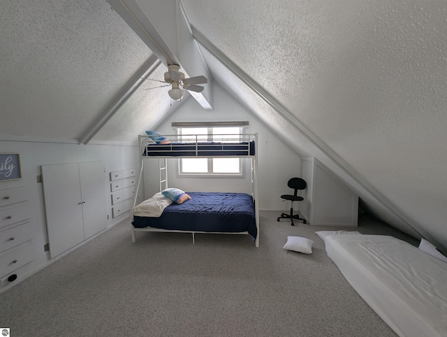 bedroom with lofted ceiling, a textured ceiling, ceiling fan, and carpet flooring