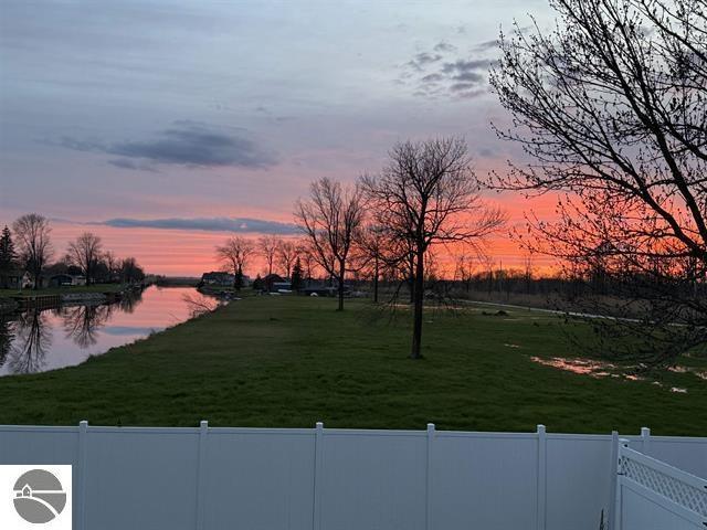 yard at dusk featuring a water view