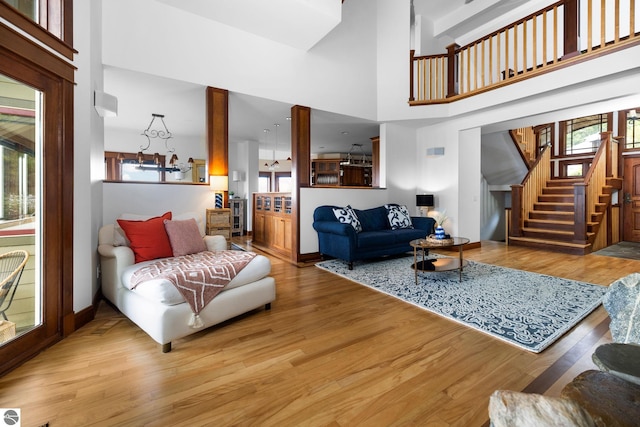 living room with hardwood / wood-style flooring and a towering ceiling