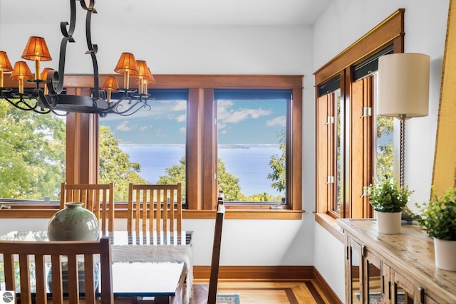 sunroom / solarium with a water view and a chandelier