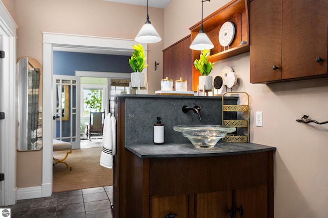 kitchen featuring hanging light fixtures, dark colored carpet, and sink