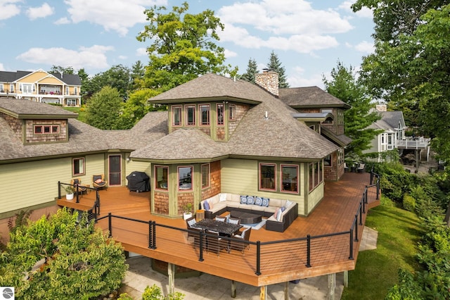 rear view of house featuring a wooden deck and an outdoor living space