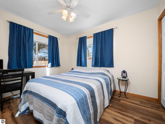 bedroom featuring multiple windows, dark hardwood / wood-style floors, and ceiling fan