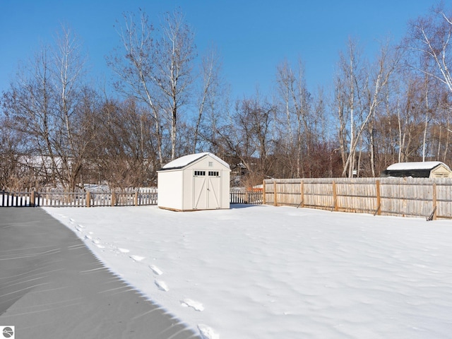 yard layered in snow with a storage shed