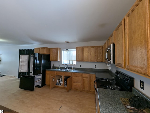 kitchen with hanging light fixtures, sink, light hardwood / wood-style flooring, and black appliances