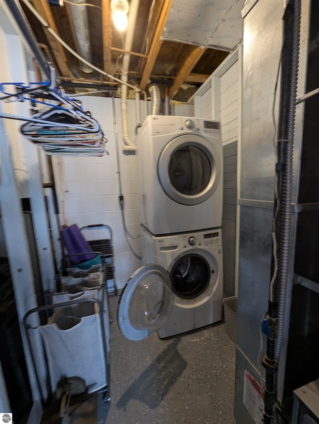 clothes washing area with stacked washer / dryer