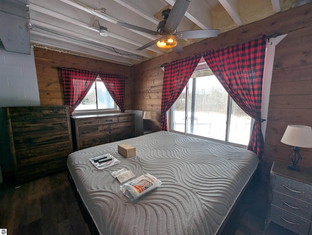 bedroom with ceiling fan, wooden walls, and beamed ceiling