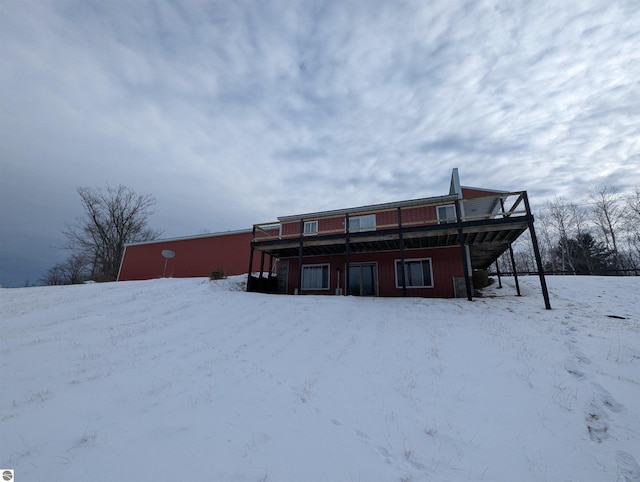 view of snow covered back of property