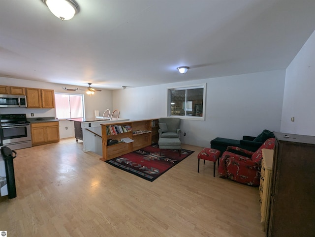 living room with ceiling fan and light wood-type flooring