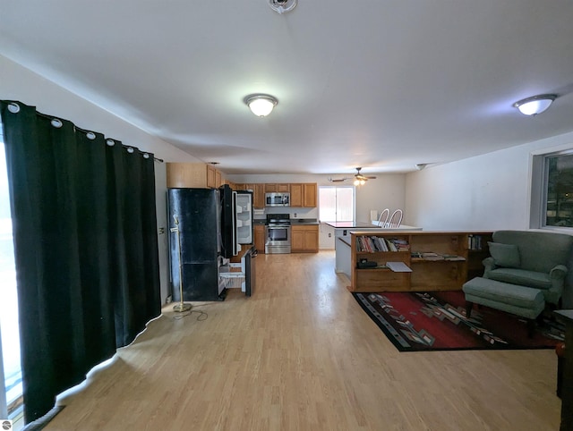 living room with light hardwood / wood-style floors and ceiling fan