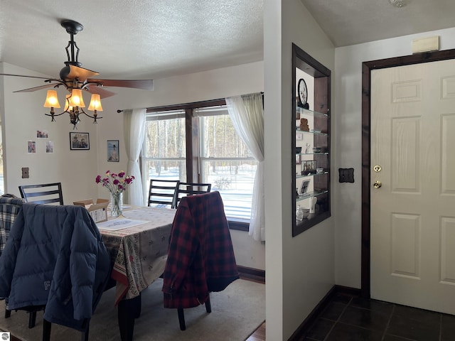 dining space with dark tile patterned flooring and a textured ceiling