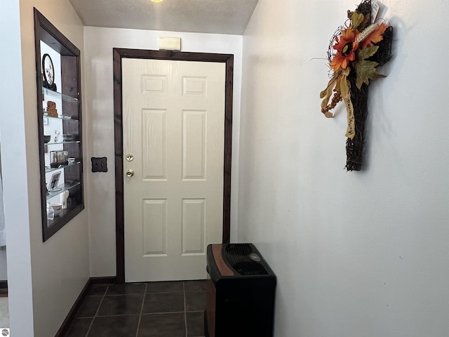 entryway with dark tile patterned floors