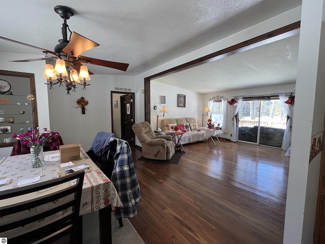 dining space featuring dark wood-type flooring, ceiling fan, and a textured ceiling