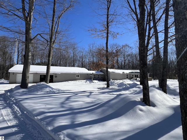 snowy yard featuring a garage