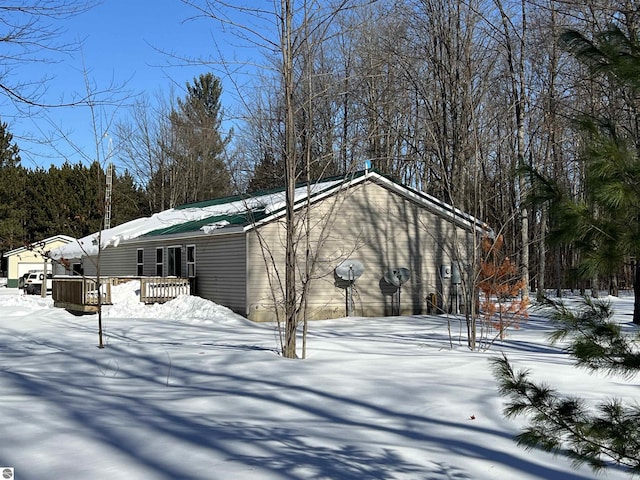 view of snowy exterior featuring a deck