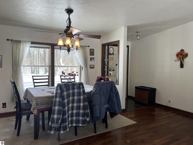 dining space with ceiling fan, dark wood-type flooring, and a textured ceiling