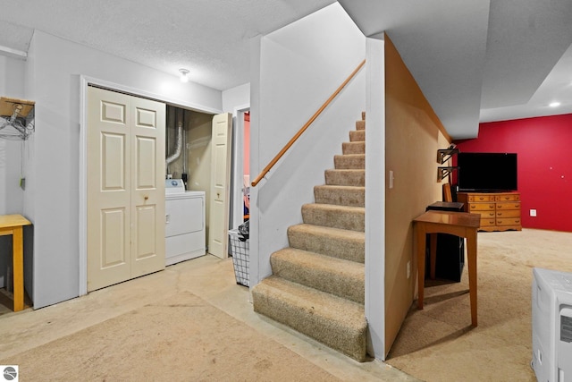 basement with washer / clothes dryer and a textured ceiling