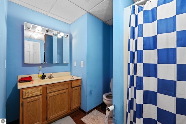 bathroom featuring hardwood / wood-style floors, a paneled ceiling, curtained shower, vanity, and toilet