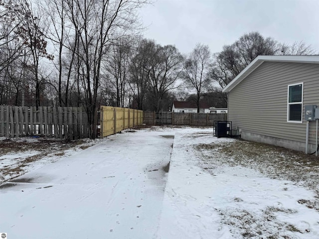 yard layered in snow featuring central air condition unit