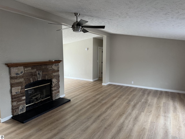 unfurnished living room with vaulted ceiling with beams, hardwood / wood-style flooring, a fireplace, and a textured ceiling