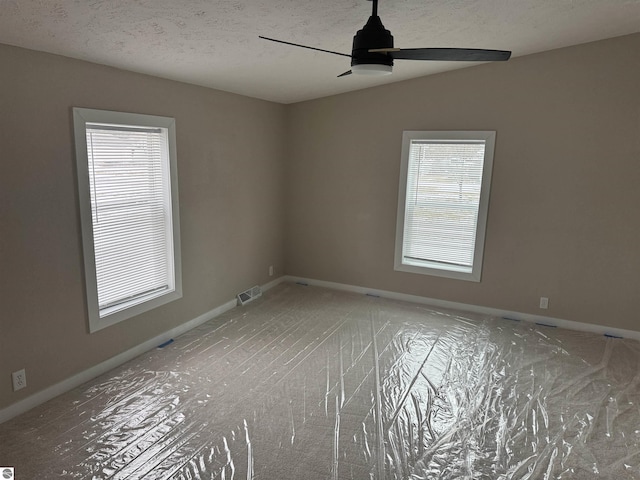 unfurnished room featuring lofted ceiling, a textured ceiling, and ceiling fan