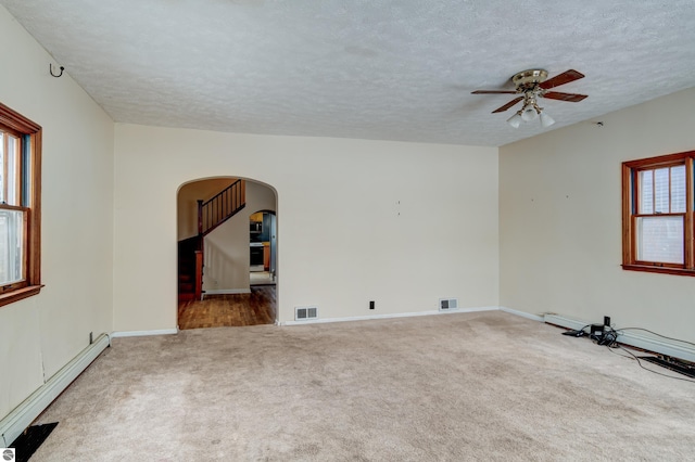 carpeted spare room featuring ceiling fan, a textured ceiling, and baseboard heating