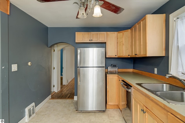 kitchen with sink, light tile patterned floors, ceiling fan, stainless steel appliances, and light brown cabinets