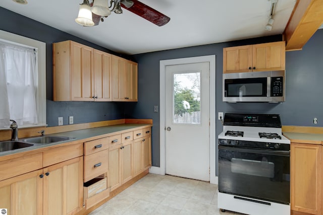 kitchen featuring sink, range with gas stovetop, ceiling fan, and light brown cabinets