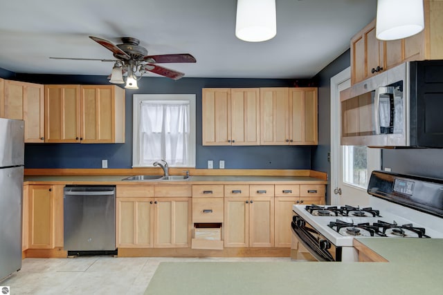 kitchen with appliances with stainless steel finishes, sink, and light brown cabinets