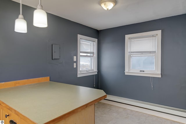 interior space with hanging light fixtures, a baseboard heating unit, and light tile patterned floors