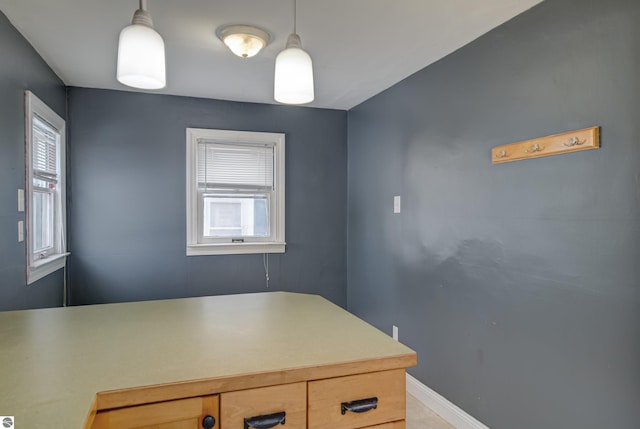 kitchen with light brown cabinetry and decorative light fixtures