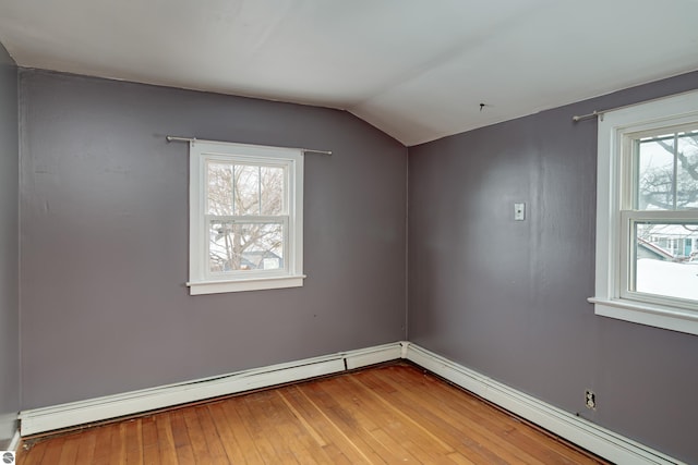 empty room featuring a baseboard radiator, lofted ceiling, and hardwood / wood-style floors